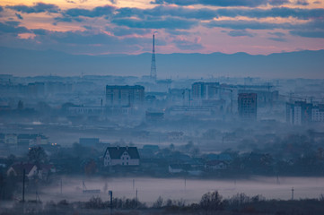 Fototapeta premium Sunset in the evening over the city in the fog