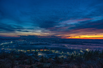 Obraz premium Sunset in the evening over the city in the fog