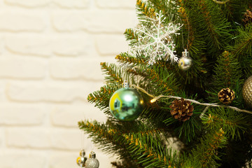 Beautiful green Christmas tree decorated with balls and garlands. Close-up photo