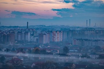 Sunset in the evening over the city in the fog