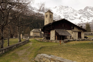 Obraz premium Veduta della Chiesa Vecchia a Macugnaga con sullo sfondo il Monte Rosa e nuvole