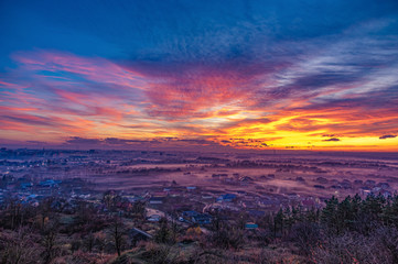 Sunset in the evening over the city in the fog