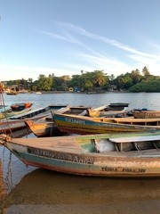 Wooden boats over calm river at sunset