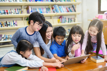 Group of Asian Student Kid Learning to use Laptop in Library with Women Teacher, Shelf of Books in Background, Asian Student Education Concept - 304709225