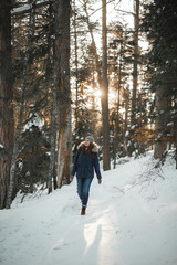 Fototapeta na wymiar Beautiful smiling young woman walking in winter forest. Winter concept