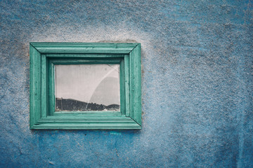 Texture wall. A framed window on a blue wall.