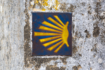 Yellow scallop shell, touristic symbol of the Camino de Santiago showing direction on Camino Norte in Spain. Signing the way to Santiago De Compostela on the St James pilgrimage route.
