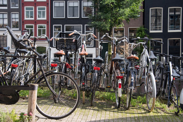 Fototapeta na wymiar Bicycles parked on a bridge in Amsterdam, The Netherlands. A lot of parked bikes on the pavement