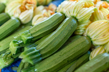 Young zicchini vegetables with yellow flowers on farmer market