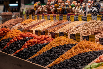 Dried fruits on the market shelves. Bright tasty delicacies. Dried apricots, raisins, prunes and nuts in the eastern bazaar. The inscriptions in Russian indicate the name of the products.