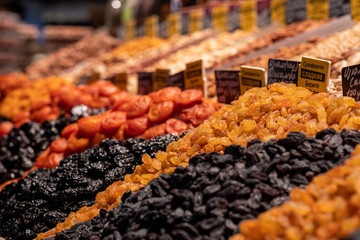 Dried fruits on the market shelves. Bright tasty delicacies. Dried apricots, raisins, prunes and...
