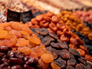 Dried fruits on the market shelves. Bright tasty delicacies. Dried apricots, raisins, prunes and nuts in the eastern bazaar. The inscriptions in Russian indicate the name of the products.