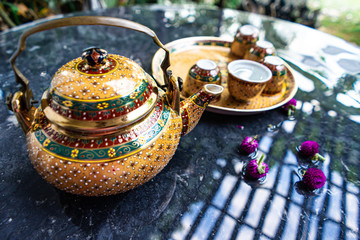 Obraz na płótnie Canvas Antique Benjarong porcelain golden tea set on Stone table , ceramics porcelain