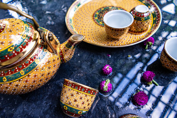 Antique Benjarong porcelain golden tea set on Stone table , ceramics porcelain