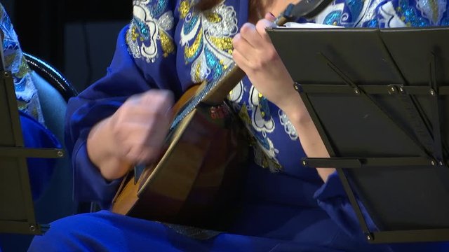 Playing the domra. Russian plucked instrument.
