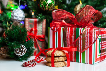 Christmas gift boxes and sweets near decorated Christmas tree