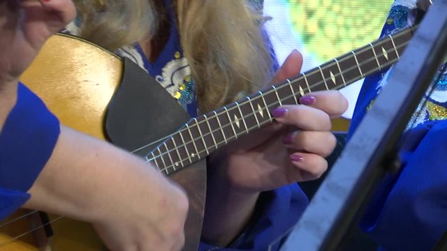 Playing the domra. Russian plucked instrument.