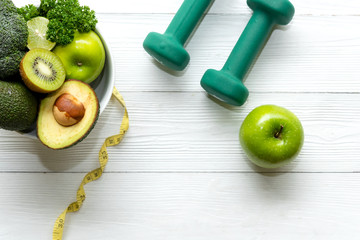 Healthy lifestyle for women diet with dumbbells sport equipment, sneakers, measuring tape, fruit healthy green apples and bottle of water on wooden.  Healthy Concept.. - obrazy, fototapety, plakaty