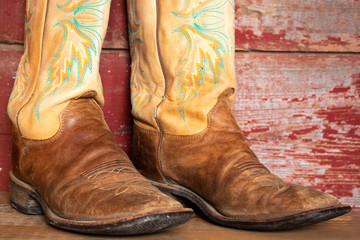 Cowboy boots on red barn board