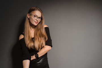 Elegant smiling woman in eyeglasses on black background