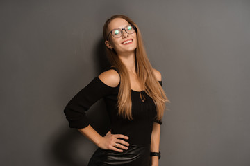 Elegant smiling woman in eyeglasses on black background