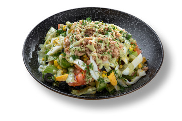 Fresh green salad with tuna fish in beautiful black modern plate