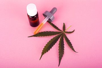 hemp oil for medical use, bottles with medical cannabis extract on pink background