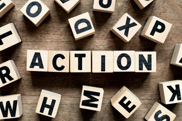 Letter block with word action on wood background with another alphabet as frame