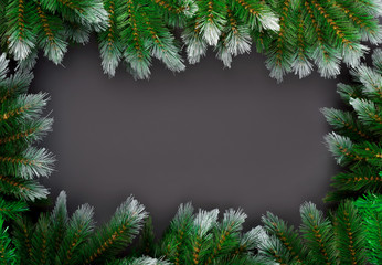 Template for Christmas card with fir tree border and copy space. Wooden table and natural pine branches.