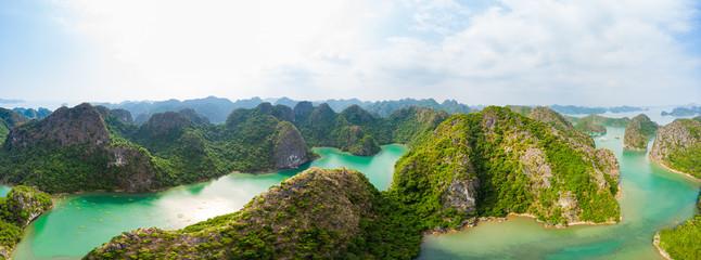 Aerial view of Ha Long Bay Cat Ba island, unique limestone rock islands and karst formation peaks in the sea, famous tourism destination in Vietnam. Scenic blue sky.