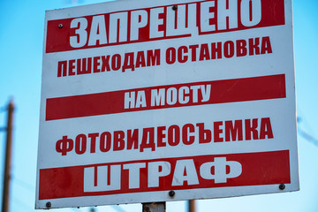 Naklejka premium the billboard forbidding walking and taking photos and videos is written on the billboard in red letters: “Pedestrians are forbidden to stop on the bridge, photo and video shooting is forbidden, fine”