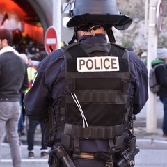 Helmeted policeman force photographed from back during a demonstration