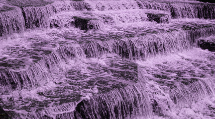 Water Cascading over Weir Steps on canal slipway showing blur blurred motion and freeze frame of water droplets for background tectures and layer effects