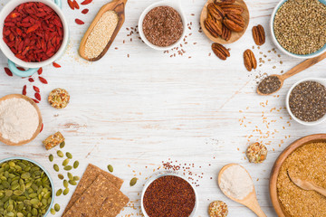 Spoons and bowls full of superfoods with space in center
