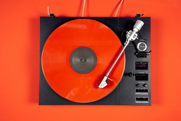 Colored vinyl record on a red background with copy space.