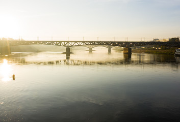 Drone flies to a railway bridge passing over the Vistula River in Warsaw. Poland. 04. October. 2019.  Aerial view of a bridge in the fog in the early morning at sunrise.