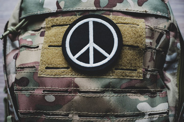 Peace Sign patch on camouflage backpack, vintage look