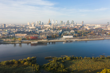 Fototapeta premium Warsaw, Poland. City landscape at sunrise. Aerial view of the river and the city with skyscrapers and buildings in the early morning.