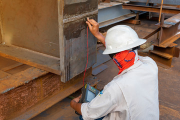 The inspectors are checking defect in welded of steel add joint with process Ultrasonic testing (UT) of Non-Destructive Testing(NDT) at industrial factory.