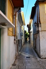 Obraz na płótnie Canvas Lefkada, Lefkada Island, Greece. 10/22/2019. narrow streets, old houses with lanterns, balconies, green plants, bright flowers in a European town on the island. cityscape, street without people