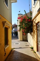 Obraz premium Lefkada, Lefkada Island, Greece. 10/22/2019. narrow streets, old houses, windows, doors, balconies, green plants, bright flowers in a European town on the island. cityscape, street without people