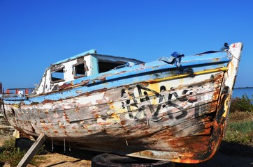Lefkada, Lefkada Island, Greece. 10/22/2019. broken old wooden ship of blue and white color, fishing boat standing on land in port