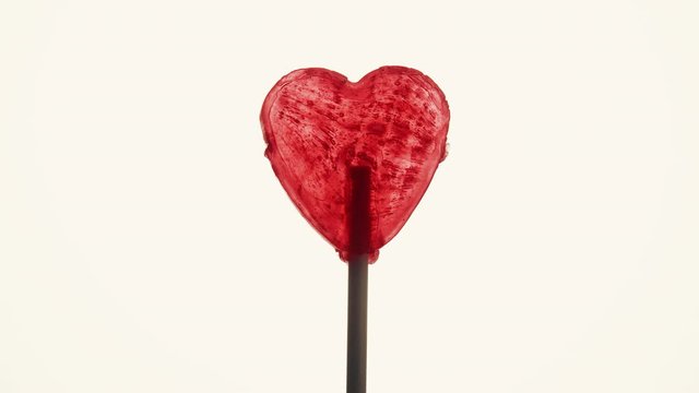 Sweet candy heart on stick against bright background. Love, valentines day or charity concept