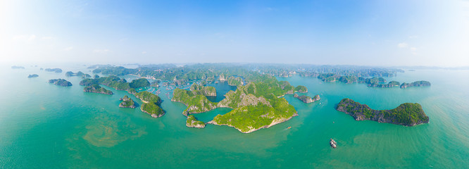 Fototapeta na wymiar Aerial view of Ha Long Bay Cat Ba island, unique limestone rock islands and karst formation peaks in the sea, famous tourism destination in Vietnam. Scenic blue sky.