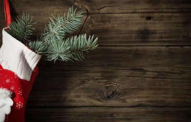 Christmas stocking with gifts hanging on dark old wooden backgro