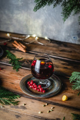mulled wine in glasses with anise, citrus and berries on brown wooden table, Christmas decoration, copy space