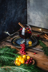 mulled wine in glasses with anise, citrus and berries on brown wooden table, Christmas decoration, copy space