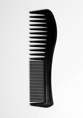 Black comb on white background.Hairdressing accessories