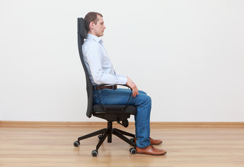 caucasian man sitting on office chair in correct  position