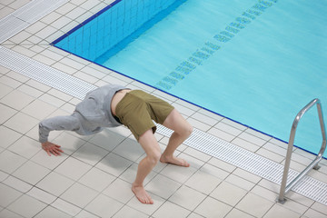 White  man in a hoodie doing bridge exercise